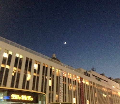 駅ビルの上にかかった月