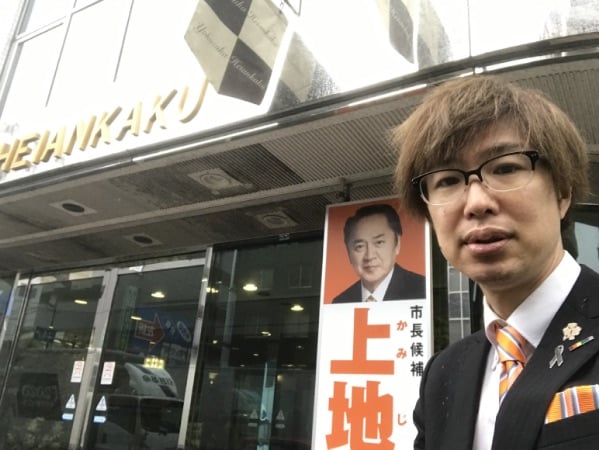 上地克明・横須賀市長候補の出陣式の会場入口で案内をする藤野英明