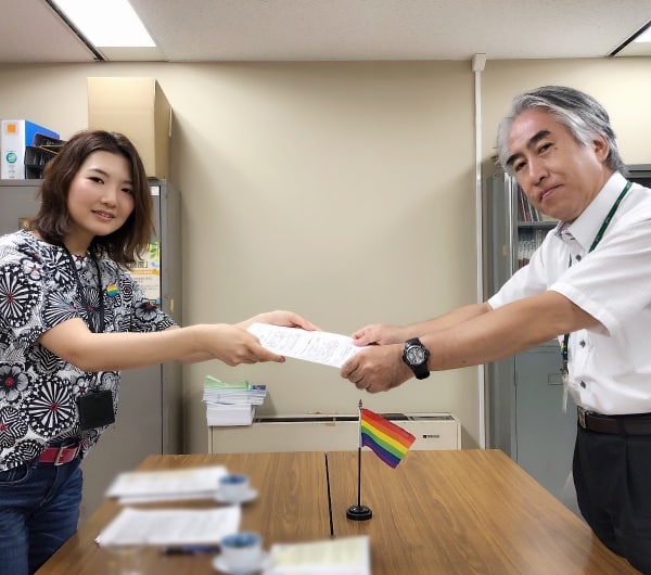 人権・男女共同参画課長に要請書を手渡す「多様な性にYESの日横須賀」代表（左）